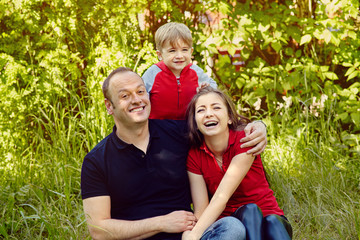 Naklejka na ściany i meble outdoor portrait of a happy family. Mom, dad and child.