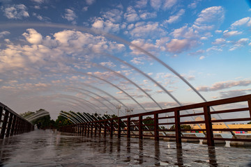 Bridge with fountain in the Aspire park during dramatic sunset in Doha, Qatar
