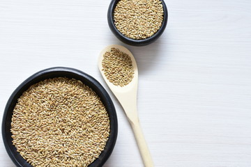 Seed of birdseed, food for birds, displayed in containers on white wooden background
