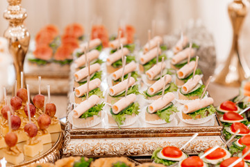 Original appetizer of canap with salted herring and cards of the potato. Rustic. Close-up.wedding...