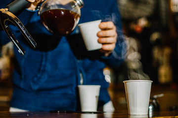brewing coffee siphon. step by step cooking instructions. coffee is ready. Barista pouring brewed coffee in the cup
