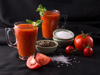 tomato juice in a glass on a black background.