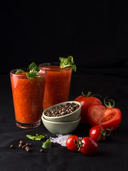 tomato juice in a glass on a black background.