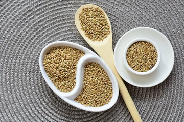 birdseed seeds, food for birds, displayed in containers on cloth bottom
