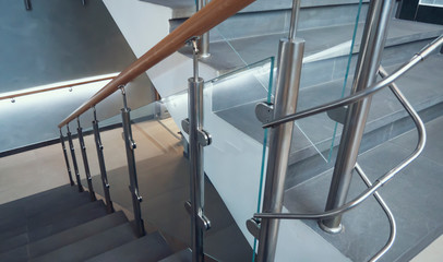 indoor staircase step with stainless steel and glass handrail.