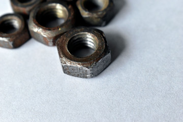 Rusty old battered iron nuts on a white background