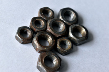 Rusty old battered iron nuts on a white background