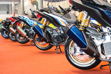 Fototapeta na wymiar motorcycles parked on the motorcycles parking lot, Closeup of motorcycles front wheel. 