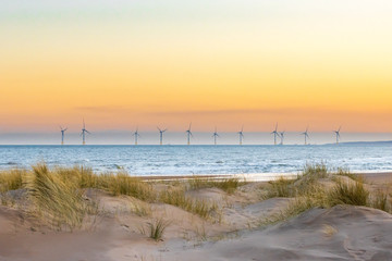 Offshore windfarm with sand dunes in the foreground 