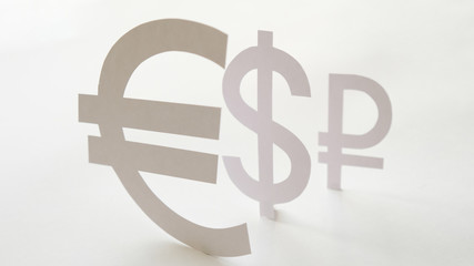 Badges of the currency, cut out of paper. The concept of devaluation of the ruble.