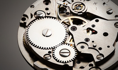 mechanizm zegara wewnętrznego widok z bliska z błyszczącym metalem i szarym tłem, zdjęcie dla przemysłu - 329643466