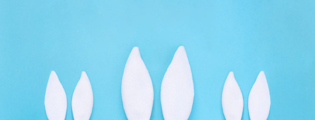 Flat lay composition of creative Easter bunny ears on blue background, space for text