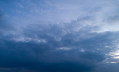 Dark cloudy sky with red reflections at sunset.