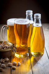 Light frothing beer in a glass, on an old background.