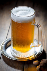 Light beer in a glass on a table in composition with accessories on an old background