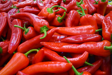 Heap Of Big Red Peppers At the market. red background. healthy eating.vegan style.