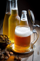 Light beer in a glass on a table in composition with accessories on an old background