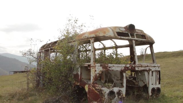 Rusty bus wreck in the forest in Pripyat. Chernobyl nuclear disaster. Slider shot - Juni 2017: 30km Chernobyl, exclusion zone