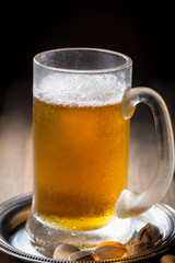 Light beer in a glass on a table in composition with accessories on an old background