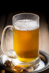 Light beer in a glass on a table in composition with accessories on an old background