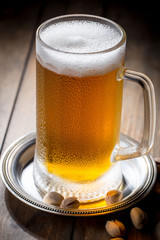 Light beer in a glass on a table in composition with accessories on an old background