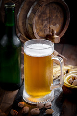 Light beer in a glass on a table in composition with accessories on an old background