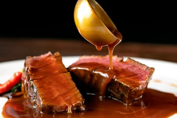 Tuinposter Grilled beef Steak filet Mignon medium rare pour demi-glace sauce © Andrey