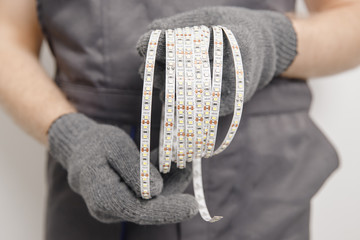 Electrician installing mounting tape LED strip light decorative lighting