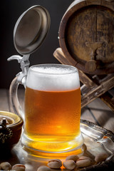 Light beer in a glass on a table in composition with accessories on an old background