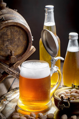 Light beer in a glass on a table in composition with accessories on an old background