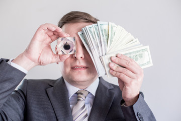 Businessman in suit holds in hands,looks to drop of black oil of Brent brand.Crystal cube.Pack of...