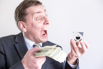 Nervous businessman in suit holds in hands drop of black oil of Brent brand and pack of dollars,...
