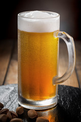 Light beer in a glass, on an old background.