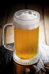 Light beer in a glass on a table in composition with accessories on an old background