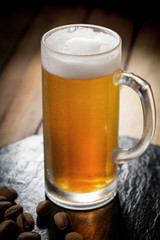 Light beer in a glass, on an old background.
