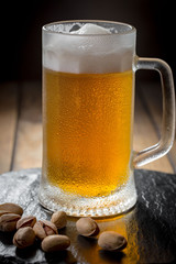 Light beer in a glass on a table in composition with accessories on an old background