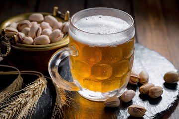 Light beer in a glass on a table in composition with accessories on an old background