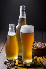 Light beer in a glass on a table in composition with accessories on an old background
