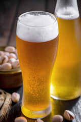 Light beer in a glass on a table in composition with accessories on an old background