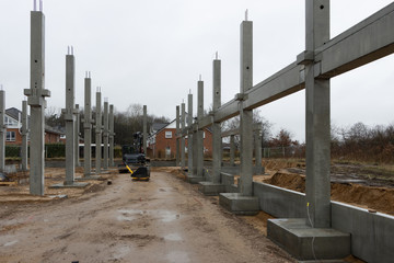 a large construction site many concrete columns are placed with the help of a crane