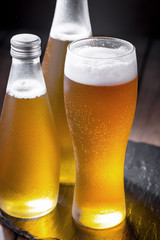 Light beer in a glass on a table in composition with accessories on an old background