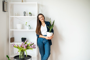 Young woman holds a flower pot in her hands
