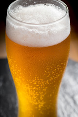 Light beer in a glass on a table in composition with accessories on an old background