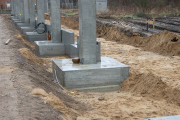 a large construction site many concrete columns are placed with the help of a crane