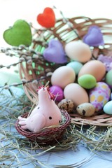 Happy Easter, a basket with painted eggs, a toy chicken, hay on the windowsill, interior decor for the holiday 