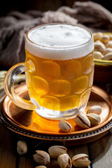 Light frothing beer in a glass, on an old background.