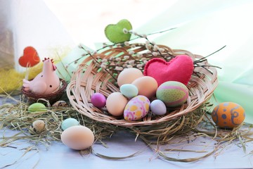 Happy Easter, a basket with painted eggs, a toy chicken, hay on the windowsill, interior decor for the holiday 