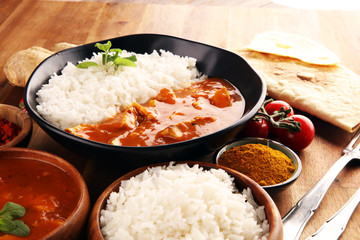 Chicken tikka masala spicy curry meat food in pot with rice and naan bread. indian food on table