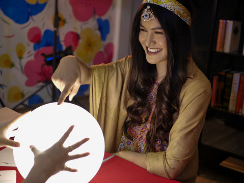 the Asian Thai fortune teller on red table with big ball crystal reader to forecast the lucky future  with divine occult magic power