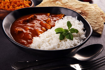 Chicken tikka masala spicy curry meat food in pot with rice and naan bread. indian food on table - obrazy, fototapety, plakaty